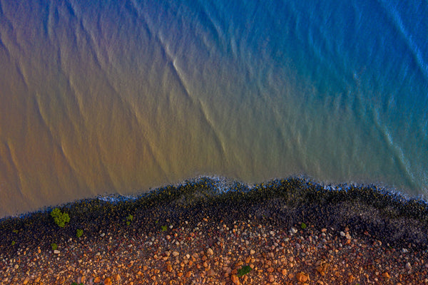 Hearson's Cove just out of Karratha captured on a stormy afternoon. This particular shot shows the wide range of colours often on display within the shelly beach. The red hues of the Pilbara Red rock contrast with the deep blues of the incoming tide.